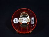 une montre posée sur une assiette rouge avec une étiquette de prix