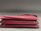 a red purse sitting on top of each other on top of a table