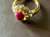 une bague en or ornée d'une pierre rouge