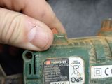 a hand that is holding a small green tool