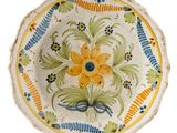 a decorative plate with a yellow flower on it