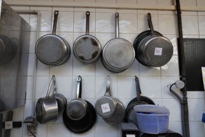 des casseroles et des poêles sont accrochées au mur d'une cuisine