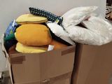 a cardboard box filled with pillows and other items