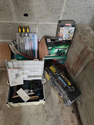 une boîte remplie de stylos et d'autres fournitures de bureau posée par terre