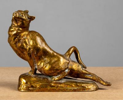 bronze statue of a cat on a rock on a table