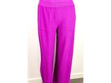 un pantalon violet sur un mannequin se tient devant un mur blanc