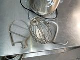 a mixer and a whisk on a metal table