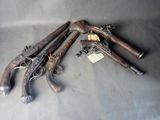 Plusieurs vieilles armes sont posées sur une table, accompagnées d'étiquettes.