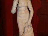 a statue of a woman holding a bag in a room