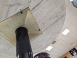 a black pole with a clock on it in a building