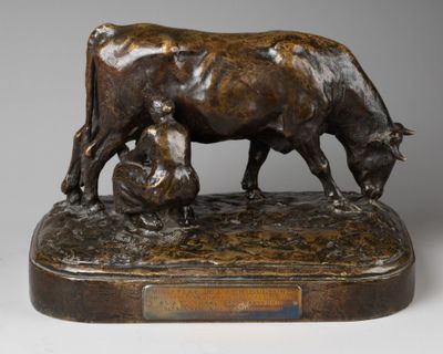 statue en bronze représentant une vache et un homme assis sur un rocher