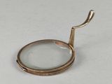 une loupe munie d'un manche, posée sur une table