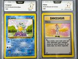 two pokemon cards are shown in plastic cases on a table