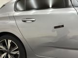 the rear of a silver car with a sticker on it ' s side