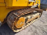 a yellow bulldozer that is parked in the dirt