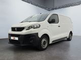 La camionnette blanche est garée à l'intérieur d'une grande pièce.
