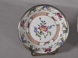 two plates with floral designs on them are sitting on a table