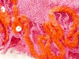 a close up of a pink scarf with orange sequins