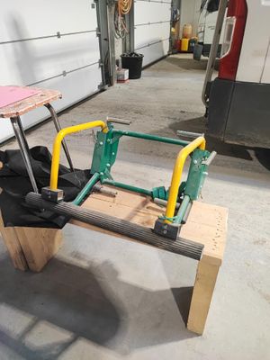 un véhicule vert et jaune avec un siège en bois dans un garage