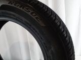 a close up of a tire on a white surface with a white curtain in the background