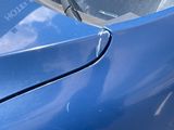 a close up of a blue car with a broken hood