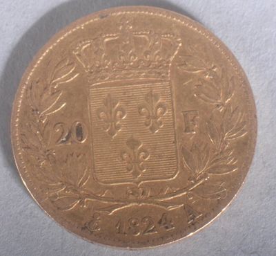 a close up of a gold coin with a coat of arms on it