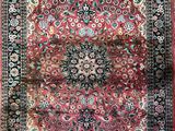 a red and black rug with a medallion design on it