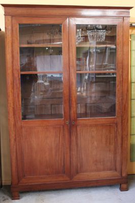 un meuble en bois avec des portes en verre dans une pièce