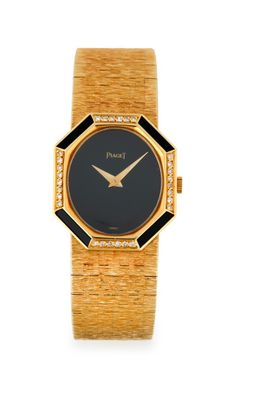 un gros plan d'une montre-bracelet en or avec un cadran noir