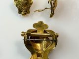 three pieces of gold on a white surface