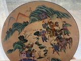 a person holding a plate with a painting on it