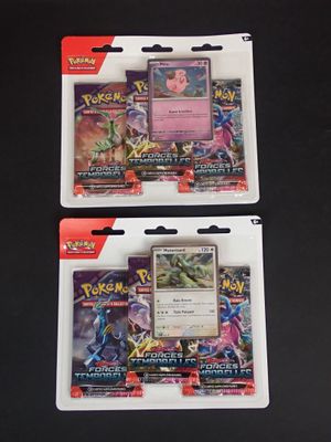 deux paquets de cartes à collectionner Pokémon posés sur une surface noire