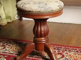 a small wooden stool with a cushion on top of it