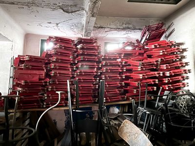 a large pile of red fire hydrants in a room