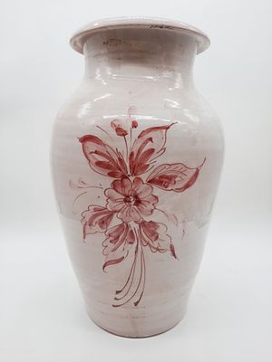 a white vase with a red flower on it