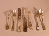 a lot of silver spoons and forks on the table