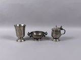three pieces of silverware are sitting on a white surface