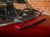 an image of a red convertible car parked in front of a brick wall