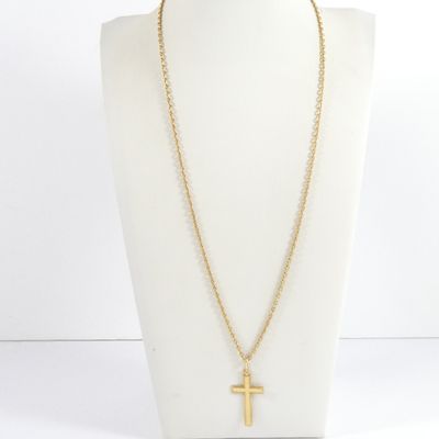 un collier en or avec un pendentif en forme de croix sur un mannequin