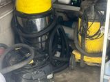 un aspirateur jaune et noir et d'autres équipements de nettoyage dans un garage