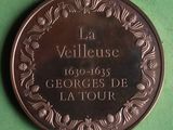 a bronze medal with the name of a village on it