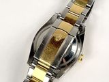 a silver and gold watch on a white surface