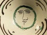 a bowl with a face painted on the side of it