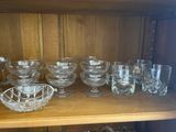 a lot of glass bowls and glasses on a shelf
