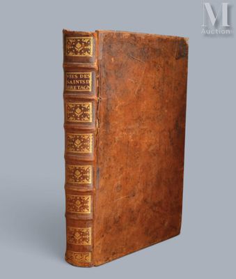 un vieux livre avec une couverture en cuir marron sur fond gris