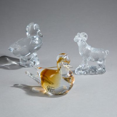 trois figurines en verre représentant des animaux, posées sur une table