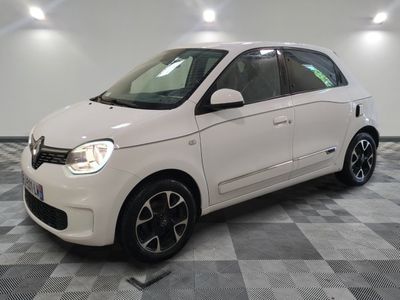 la petite voiture blanche est garée dans une pièce au sol à carreaux