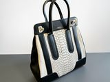 a white and black handbag sitting on top of a table