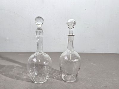 deux bouteilles en verre transparent posées l'une à côté de l'autre sur une table