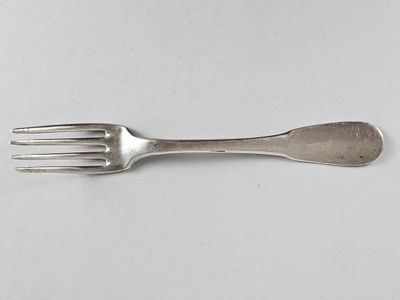 une fourchette et une cuillère posées sur une surface blanche